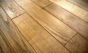 Warm-toned wooden floor with long rectangular planks and visible grain patterns