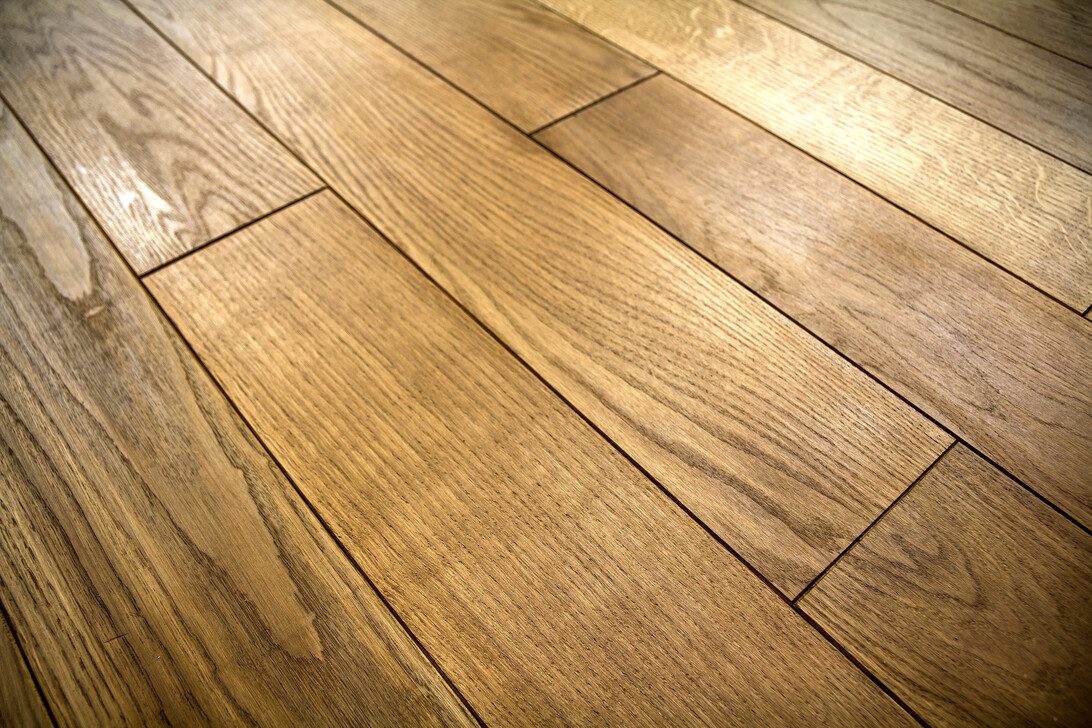 Warm-toned wooden floor with long rectangular planks and visible grain patterns
